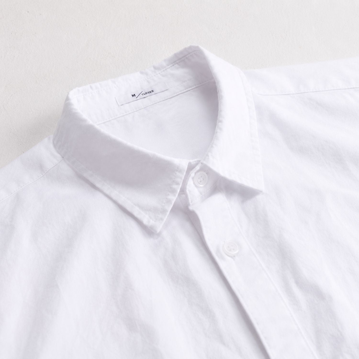 Close-up of a white man's shirt collar with buttons